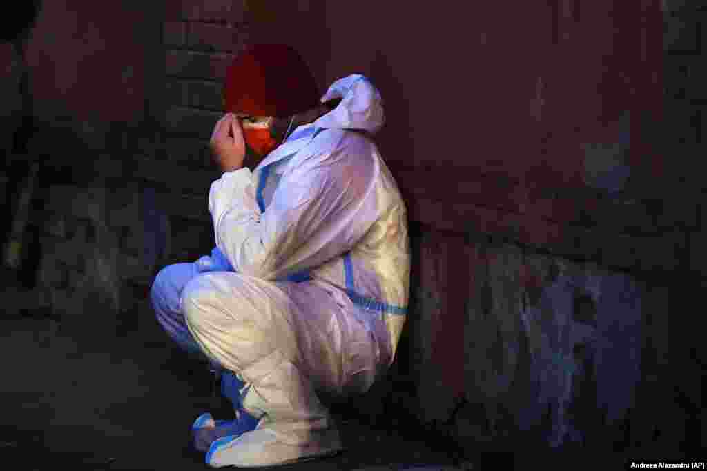 A Romanian emergency paramedic leans against a wall outside the Matei Bals hospital compound in Bucharest. (AP/Andreea Alexandru)