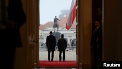 Polish President Karol Nawrocki (left) and Ukrainian President Volodymyr Zelenskyy seen from behind during a welcoming ceremony at the Presidential Palace in Warsaw in December 2025. 