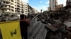 People carry Hezbollah flags at the site of an air strike in Beirut's southern suburbs on November 27.