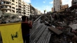 People carry Hezbollah flags at the site of an air strike in Beirut's southern suburbs on November 27.