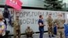 A metal fence covered with signs reading "Burn, Inter, burn!" and "Inter is a Kremlin agent!" erected after the fire remained in front of the TV offices on September 7.