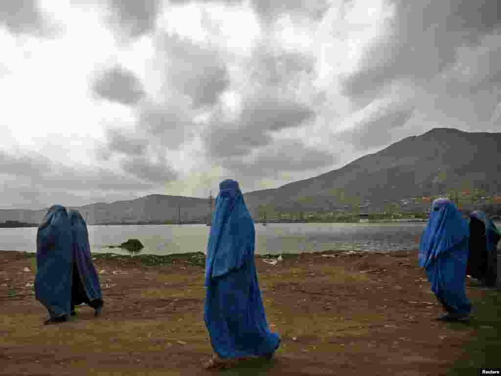 Afghan women clad in burqas walk along a road in Kabul on March 28. Photo by Ahmad Masood for Reuters
