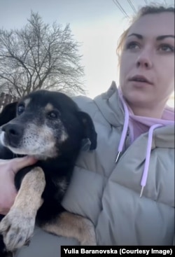Yulia Baranovska holds an elderly dog she picked up from the street in Novomyrhorod.