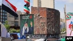 A picture of slain supreme leader Ayatollah Ali Khamenei and a sculpture of late supreme leader Ayatollah Ruhollah Khomeini stand on a Tehran street.