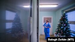 Védőfelszerelést viselő ápoló egy karácsonyfa mellett a koronavírussal fertőzött betegek fogadására kialakított intenzív osztályon a Szent László Kórházban 2020. december 8-án