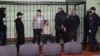 (Left to right) Dzmitry Papou, Artsyom Sakau, Uladzimer Tsyhanovich, Ihar Losik, Syarhey Tsikhanouski, and Mikalay Statkevich in the defendants' cage during the court hearing in Homel on December 14.