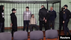 (Left to right) Dzmitry Papou, Artsyom Sakau, Uladzimer Tsyhanovich, Ihar Losik, Syarhey Tsikhanouski, and Mikalay Statkevich in the defendants' cage during the court hearing in Homel on December 14.