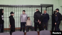 Sergej Tihanovski razgovara sa optuženicima, uključujući Dzmitrija Papua, Artsjoma Sakaua, Uladzimera Tsyhanovicha i Ihara Losika tokom sudske rasprave u Homelu 14. decembra.