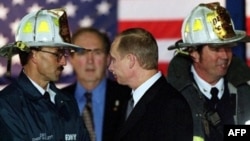 Russian President Vladimir Putin (center) with U.S. firefighters on November 15, 2001, as he visits the site of the September 11 terrorist attack that destroyed the twin towers of the World Trade Center in New York. 
