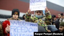 Migrants protest outside a transport and logistics center on the Belarusian side of the border with Poland on November 25.