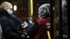 A bus conductor scans commuters' QR codes at a bus stop in Kazan, Russia.