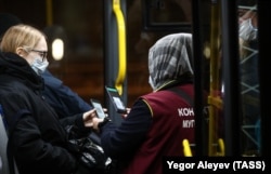 Кондуктор во время проверки QR-кодов у пассажиров в автобусе