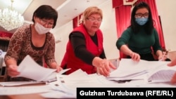 Election workers count ballots at a polling station in Bishkek.