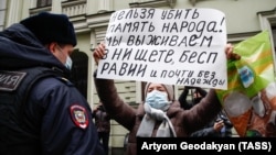 A woman holds a sign saying: "You cannot kill the memory of the people! We survive in poverty, powerlessness and [with] almost no hope," outside the Supreme Court in Moscow on November 25.