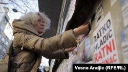 Aktivistkinja Aida Ćorović lijepi plakate na kojima piše Ratko Mladić ratni zločinac na protestu na Platou Milana Mladenovića u centru Beograda zbog murala koji slavi ovog osuđenog ratnog zločinca, 25. novembra 2021.