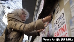 Aida Ćorović lepi plakate sa natpisom "Ratko Mladić ratni zločinac" na protestu u centru Beograda, 21. novembar 2021. godine. 