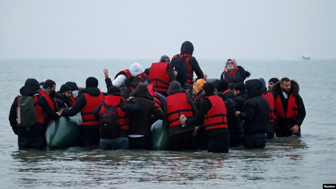 Un grup de peste 40 de migranți părăsesc coasta franceză în jurul unei bărci gonflabile cu ajutorul căreia speră să ajungă în Marea Britanie. 24 noiembrie 2021, Wimereux, Franța.