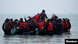 Un grup de peste 40 de migranți părăsesc coasta franceză în jurul unei bărci gonflabile cu ajutorul căreia speră să ajungă în Marea Britanie. 24 noiembrie 2021, Wimereux, Franța.