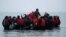 Un grup de peste 40 de migranți părăsesc coasta franceză în jurul unei bărci gonflabile cu ajutorul căreia speră să ajungă în Marea Britanie. 24 noiembrie 2021, Wimereux, Franța.