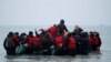 Migranti se ukrcavaju na gumeni čamac napuštajući obalu na sjeveru Francuske, 24. novembar 2021. 