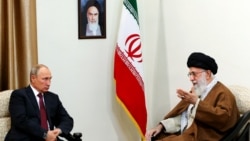 Ресей президенті Владимир Путин (сол жақта) 2017 жылы Иранға барған кезде аятолла Әли Хаменеимен кездескенде түсірілген фото. Жоғарыда қабырғада Ислам республикасының негізін қалап, 1989 жылы қайтыс болғанға дейін Иранды басқарған аятолла Рухолла Хомейнидің суреті ілініп тұр.