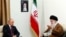 Russian President Vladimir Putin meets Iranian Supreme Leader Ayatollah Ali Khamenei during a visit to Iran in 2017. A photo on the wall shows Khamenei's predecessor, Ayatollah Ruhollah Khomeini, who founded the Islamic republic and was supreme leader until his death in 1989.