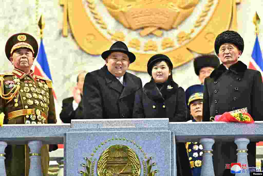 Të veshur me pallto të zeza, Kim dhe e bija ndjekin paradën ushtarake nga një ballkon.&nbsp;