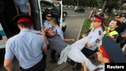 Полицейские погружают в автозак задержанного предполагаемого участника несанкционированной акции протеста. Алматы, 6 июля 2019 года. 