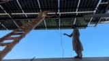 Workers install Chinese-made solar panels in Pakistan's Khyber Pakhtunkhwa province.