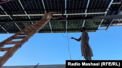 Workers install Chinese-made solar panels in Pakistan's Khyber Pakhtunkhwa Province.