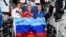 Russian cosmonauts onboard the International Space Station pose with a flag of separatist forces in Luhansk, Ukraine, on July 4.