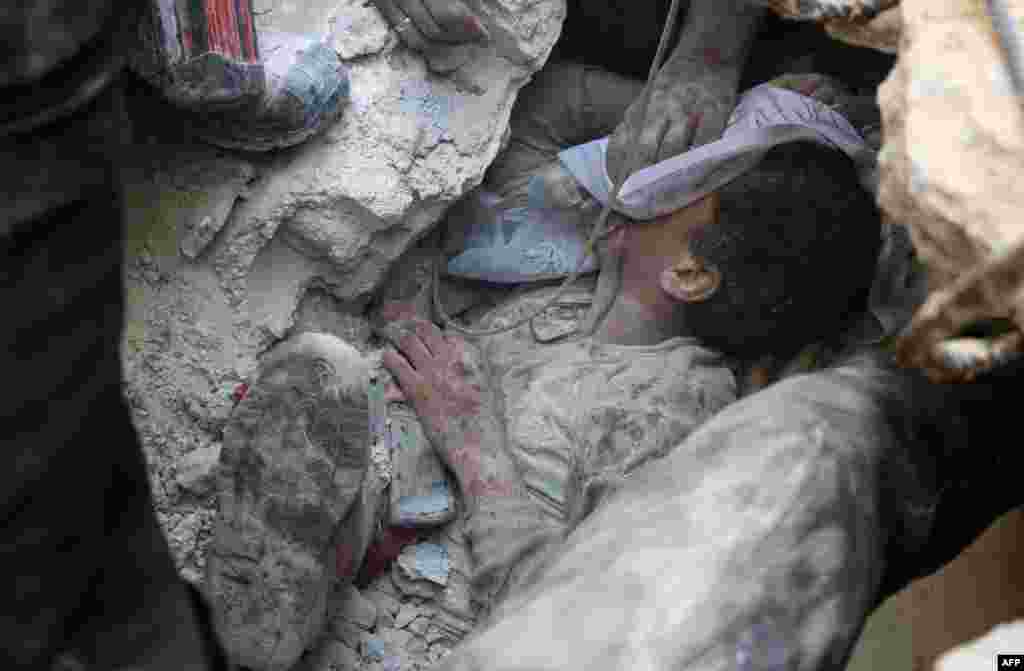 Jameel Mustafa Habboush, a young Syrian boy, receives oxygen as he is pulled from the rubble of a building following Russian air strikes on the rebel-held Fardous neighborhood of the embattled Syrian city of Aleppo. (AFP/Thaer Mohammed)