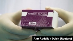 A lab technicians holds a package of remdesivir, a drug that has been used in the treatment of severe COVID-19. (file photo) 