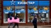 People walk past a store of Kyivstar, Ukraine's major telecommunications company, in Kyiv on December 12.