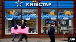 People walk past a store of Kyivstar, Ukraine's major telecommunications company, in Kyiv on December 12.