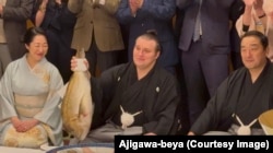 Сумоїст з тренером під час церемонії