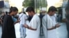 Iranian men check their phones in Tehran after a reported reopening of international internet access on May 27.