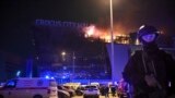 Russia - Rosguardia secures an area as a massive blaze is seen over the Crocus City Hall on the western edge of Moscow, 22Mar2024