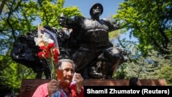 Люди у памятника в парке 28 гвардейцев-панфиловцев в Алматы. 9 мая 2018 года.