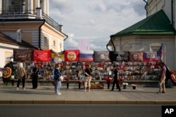 Njerëz qëndrojnë pranë një memoriali të improvizuar të shefit mercenar rus, Yevgeny Prigozhin, dhe të tjerëve, që vdiqën nga rrëzimi i një avioni vitin e kaluar, në afërsi të Kreminit, në Moskë, Rusi, 29 korrik 2024.