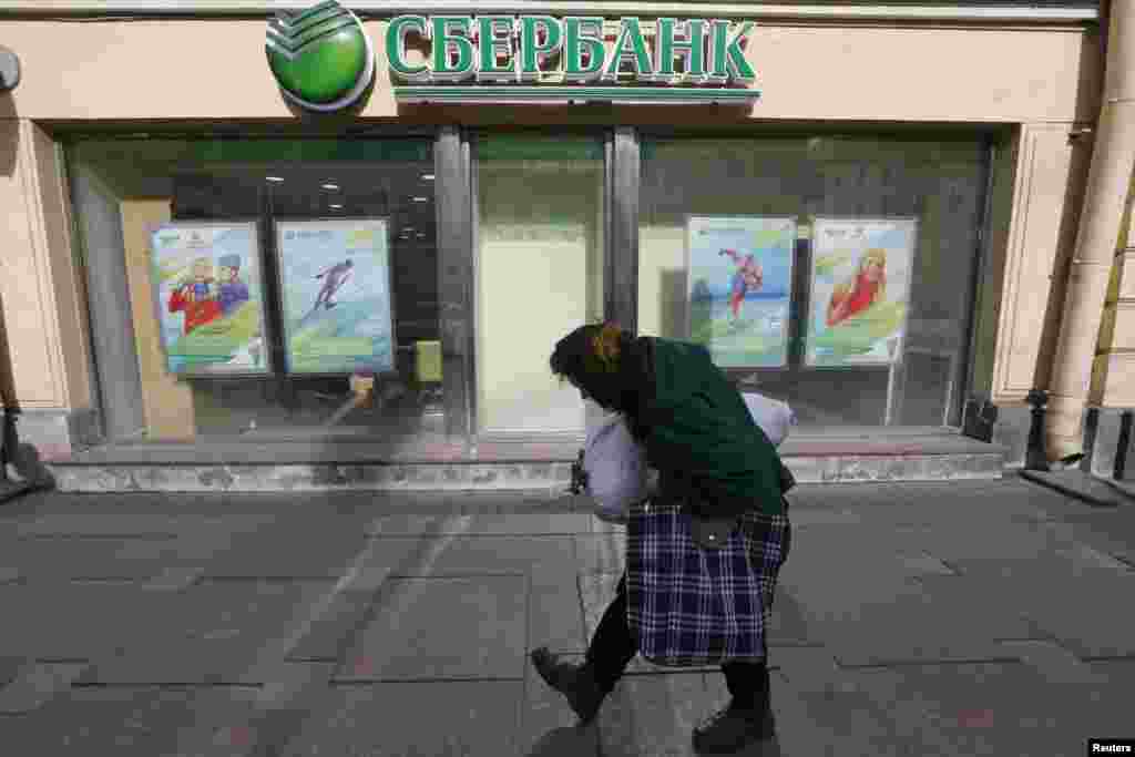 An elderly woman passes by a branch of Sberbank in St. Petersburg, Russia. (Reuters/Aleksandr Demianchuk)