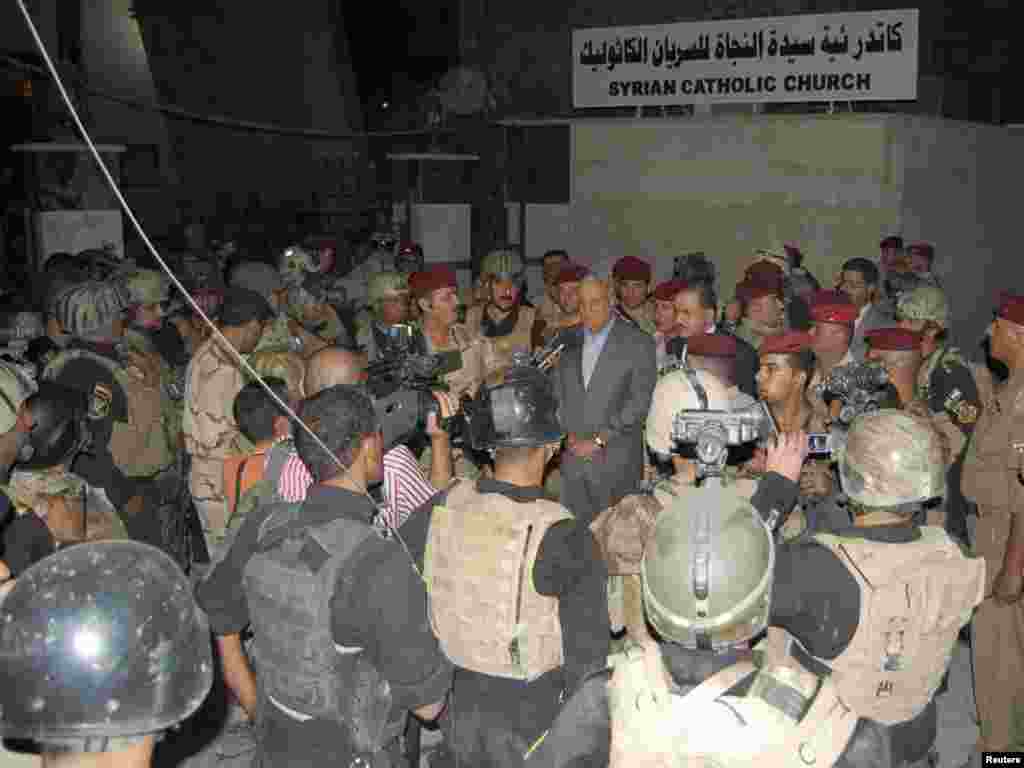 وزیر دفاع عراق در حال گفت و گو با خبرنگاران در کنار کلیسا - Iraq's Defence Minister General Abdel Qader Jassim speaks during a news conference outside the Our Lady of Salvation church in Baghdad October 31, 2010. At least seven Iraqi Catholics died on Sunday when police stormed the Baghdad church where gunmen were holding dozens of parishioners hostage, threatening to kill them if al Qaeda prisoners were not released. Picture taken October 31, 2010. REUTERS/Stringer (IRAQ - Tags: CIVIL UNREST RELIGION)