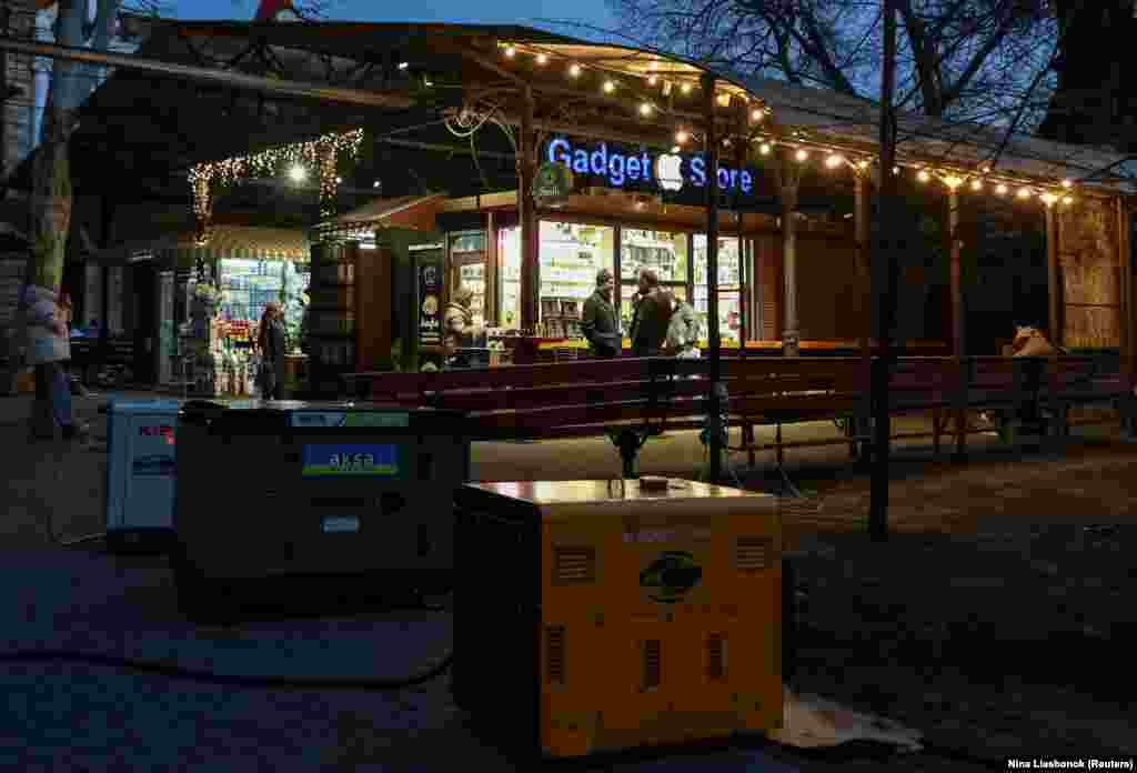 Люди відвідують вуличний ринок, що працює від генераторів, під час відключення електроенергії після нещодавніх російських атак, Одеса, 15 грудня 2025 року