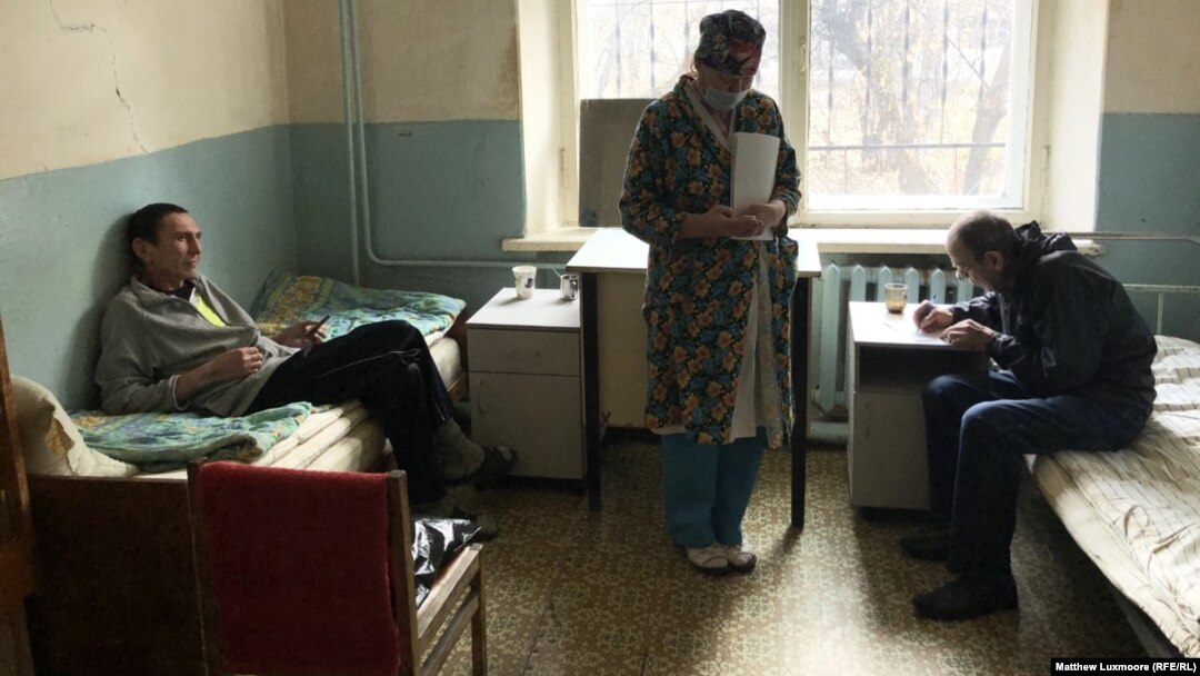 A nurse treats Ivan Korobenkov (left) and another TB patient at the treatment center in Chernavsky. Doctors at the center say they are forced to buy their own face masks since the state does not supply enough.