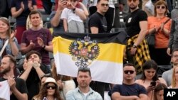 Prietenia ruso-sârbă iese la lumină în forme uneori bizare: un fan ține steagul Rusiei imperiale la un meci de tenis între sârbul Novak Djokovic și rusul Andrei Rublev, la Belgrad, în aprilie 2022. 