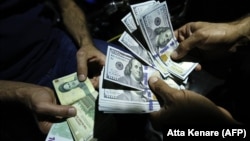 IRAN -- A man exchanges Iranian Rials against US Dollars at an exchange shop in the capital Tehran, August 8, 2018