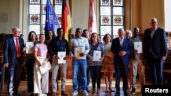 Njemački kancelar Olaf Scholz pozira za grupnu fotografiju na dan ceremonije naturalizacije, nakon što je njegova vlada skratila put do državljanstva za strance i ukinula zabranu dvojnog državljanstva, u Bremenu, Njemačka, 19. augusta 2024.