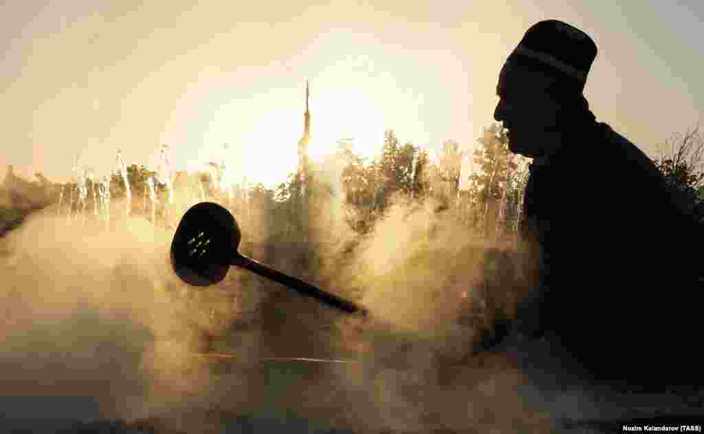 DUSHANBE, TAJIKISTAN - OCTOBER 29, 2021: A man cooks pilau at the Oshi Palav festival held at the Navruzgokh state enterprise. Some 3.5-4 tons of pilau have been cooked in the largest cooking pot during the festival. Nozim Kalandarov/TASS