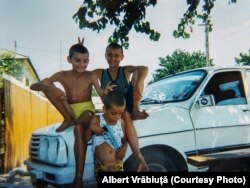 Albert Vrăbiuță în copilărie, fotografiat pe capota unei mașini Dacia împreună cu prietenii săi.