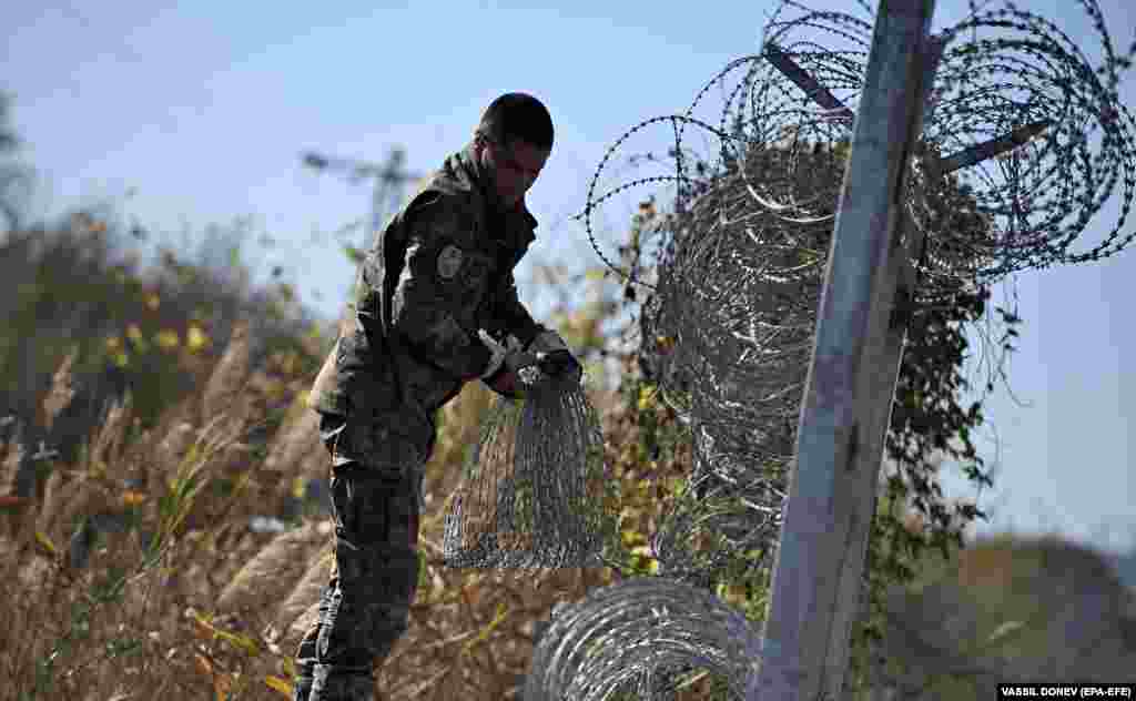 A Bulgarian soldier repairs a protective fence at the Bulgarian-Turkish border near the village of Matochina. The Bulgarian government has urged urgent repairs to the fencing, which prevents the entry of refugees from Turkey.